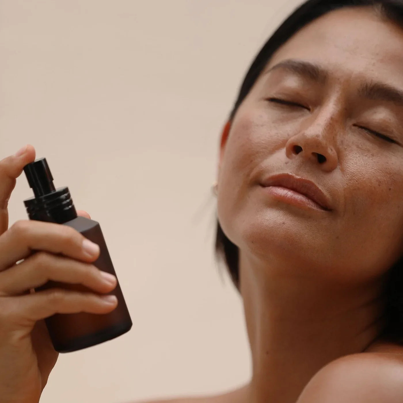 Woman in studio spraying 'Iliahi Sandalwood Hydrosol Mist & Toner