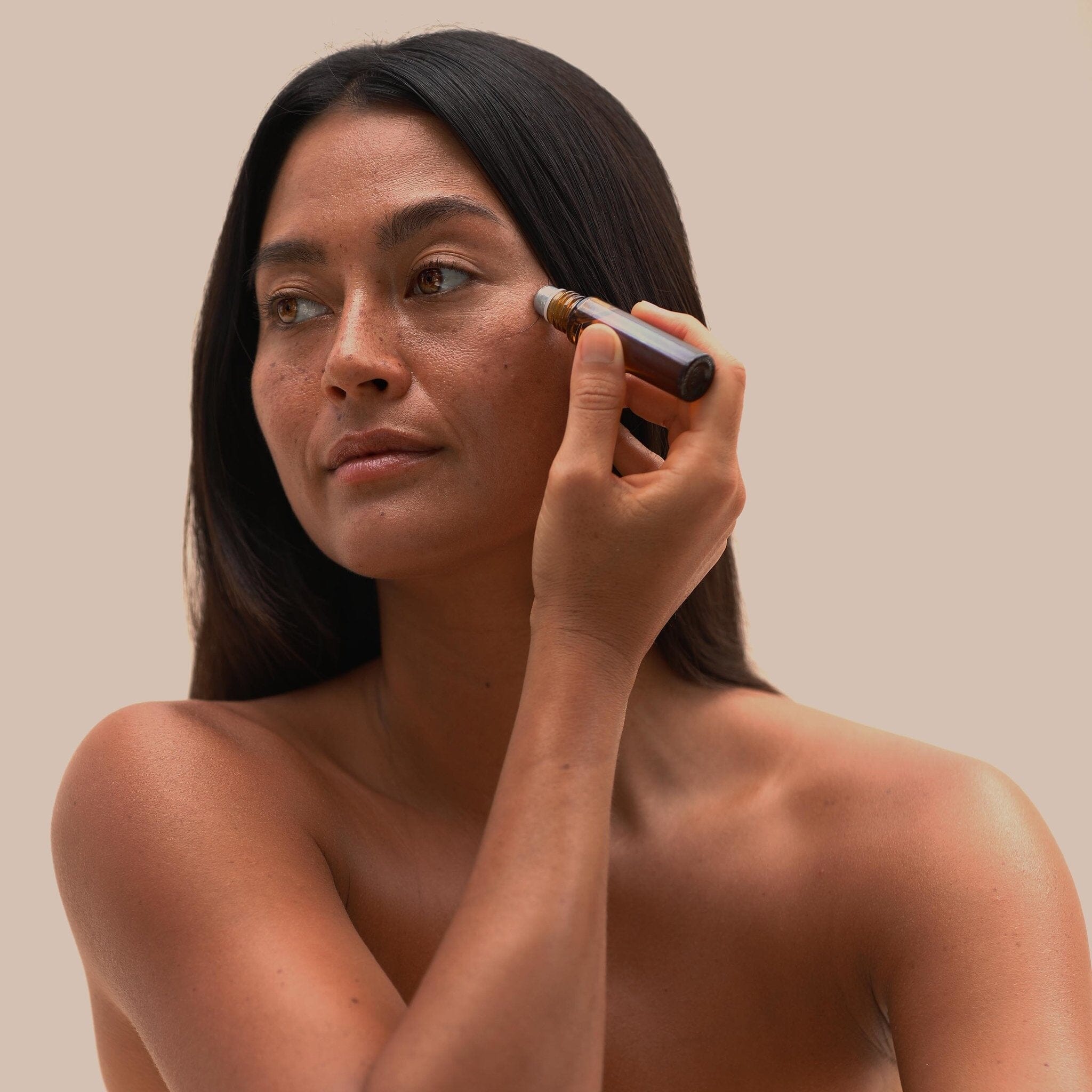 Woman applying Iliahi Sandalwood Roller Perfume to her face