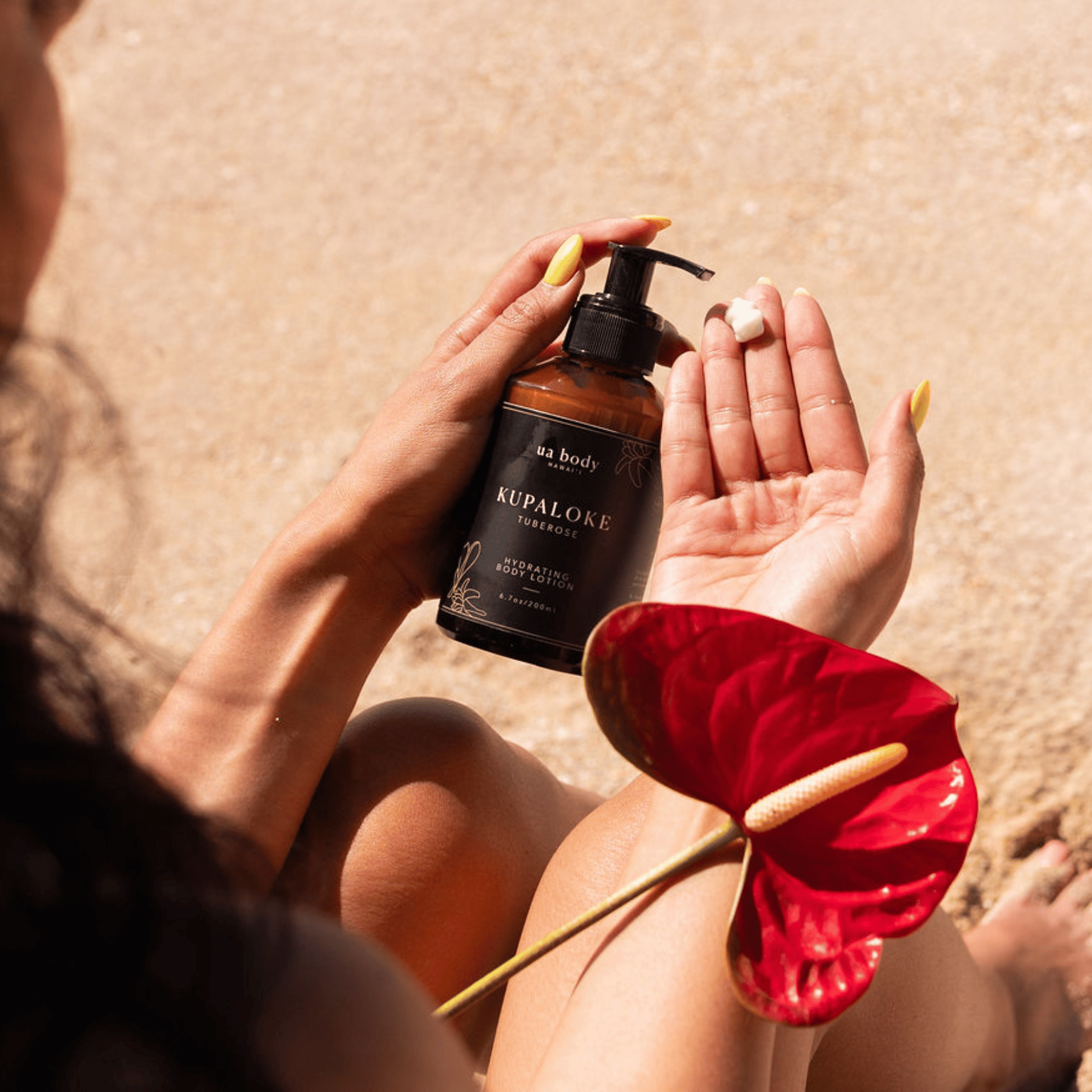 Woman on beach putting body lotion in her hand 