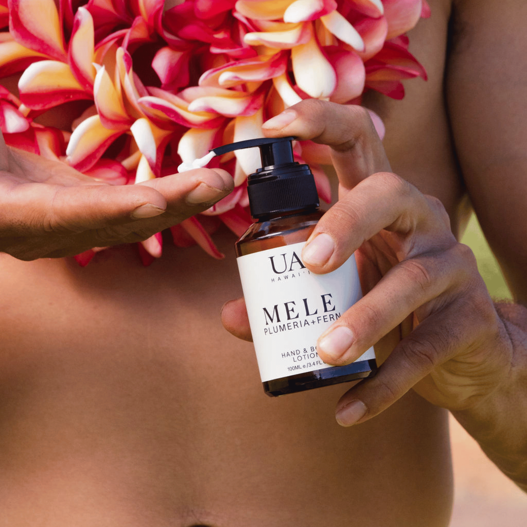 Bare chested man with plumeria lei and pumpkin Mele body lotion into hand