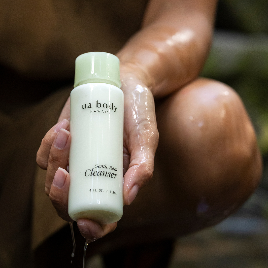 Woman holding cleanser while water drips down bottle