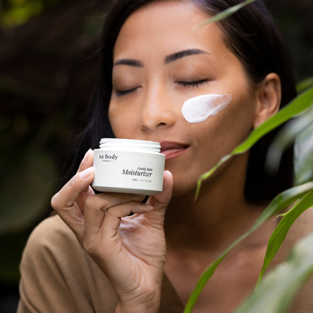 Woman smelling moisturizer jar with cream on face